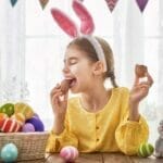 child eating an easter egg with dye